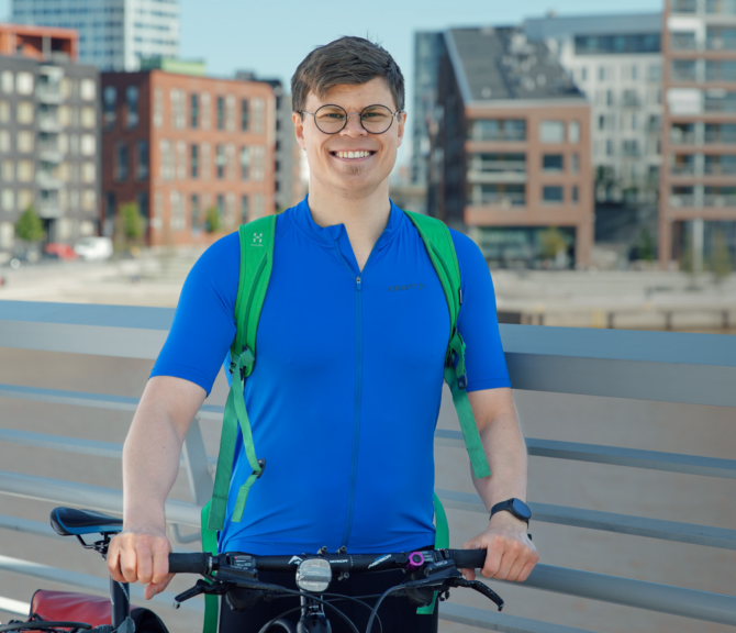 Juho Salmi taluttaa polkupyörää sillalla.