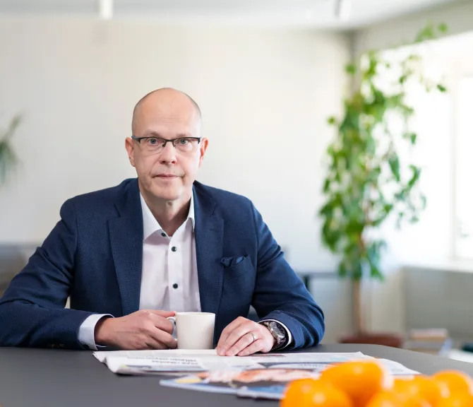 Teemu Hankamäki katsoo kameraan työpöydän ääressä.