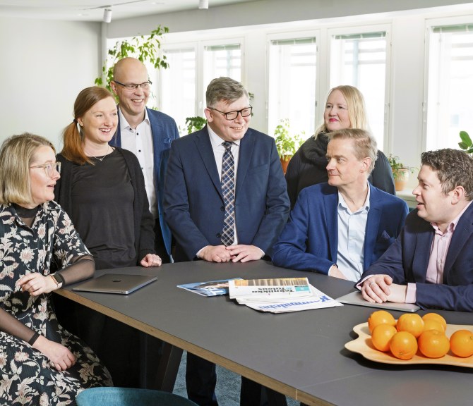 Johtoryhmä pöydän ääressä