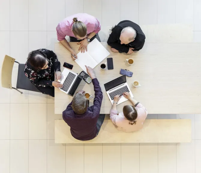 Ryhmä ihmisiä pöydän ääressä