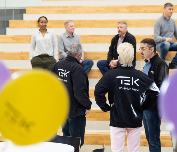 Henkilöitä TEK-hupparit päällä.