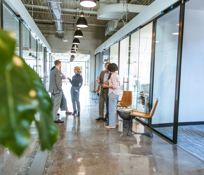 Henkilöitä keskustelemassa käytävällä.