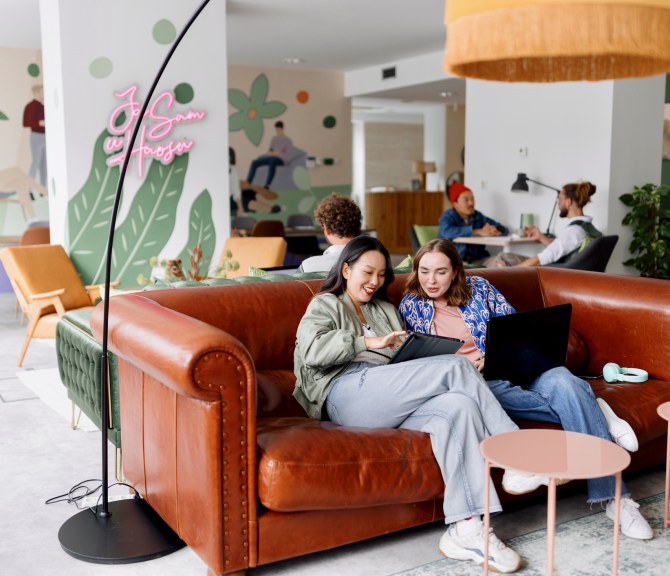 Nuoret henkilöt kahvilassa sohvalla.