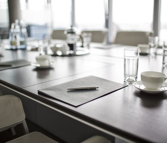 Kokouspöydällä papereita ja laseja.