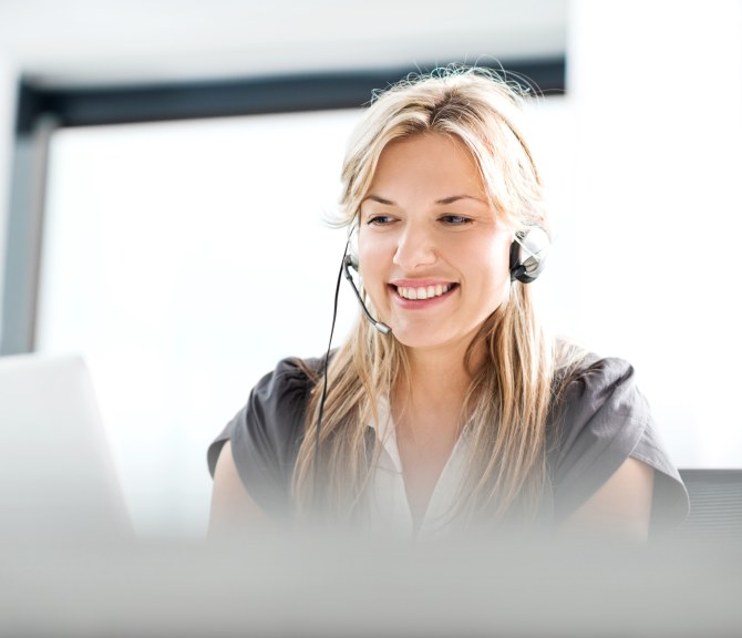 Henkilö kuulokkeet päässä läppärillä.