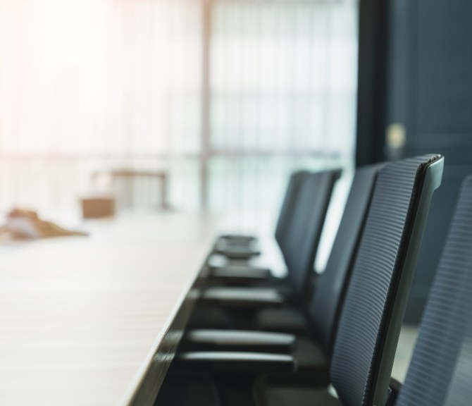 Tuoleja neuvottelupöydän äärellä.