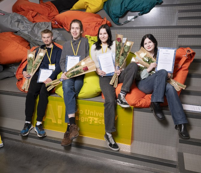 Kipinä-kilpailun voittaneet neljä nuorta istuu vierekkäin portaikossa.