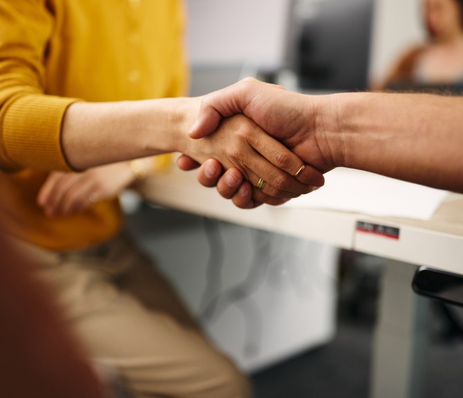 Henkilöt kättelevät.