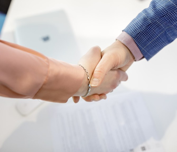 Kaksi henkilöä kättelee.