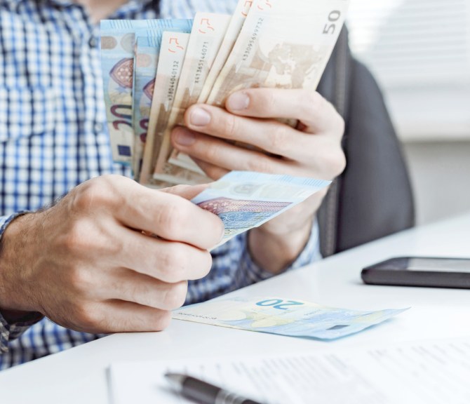 Mies laskee rahaa.