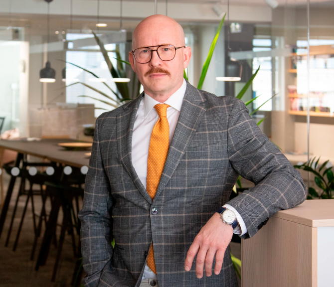 Jussi Nousiainen toimistossa kasvoillaan vakava ilme.