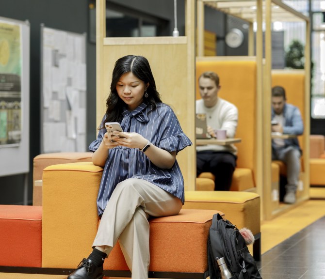 Henkilöitä katsomassa puhelimia.