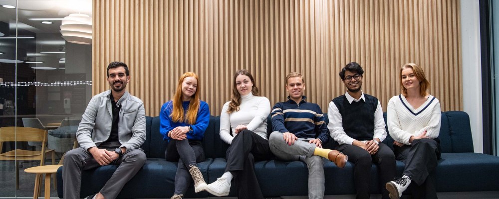 Teekkariporukka istuu sohvalla Kuopiossa.