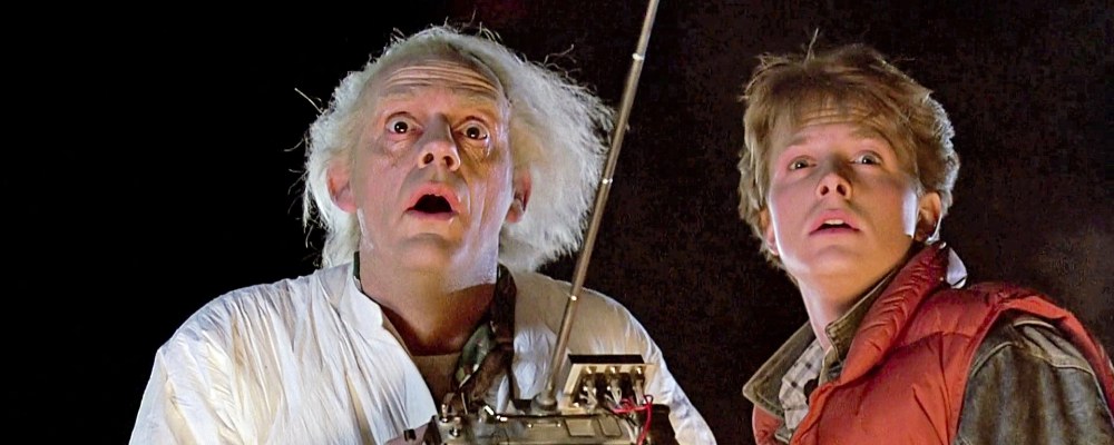 Emmett ”Doc” Brown ja Marty McFly seisovat vieretysten elokuvasta Paluu tulevaisuuteen otetussa still-kuvassa.