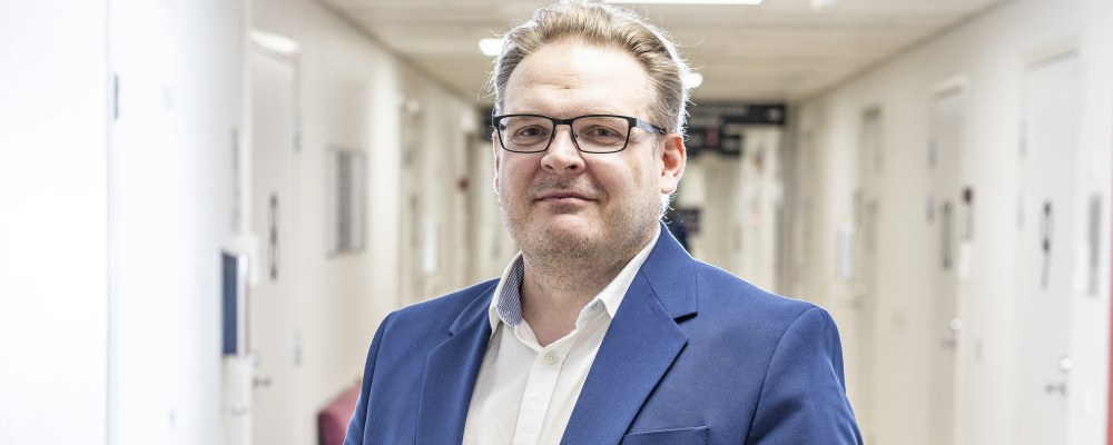 Toni Suihko seisoo käytävällä.