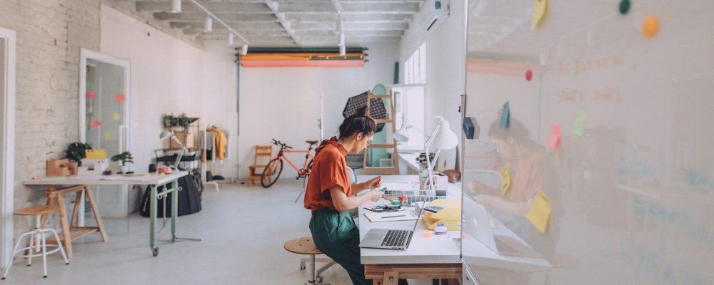 Nainen työskentelee tietokoneella modernissa toimistossa