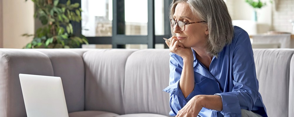 Nainen istuu tietokoneen äärellä