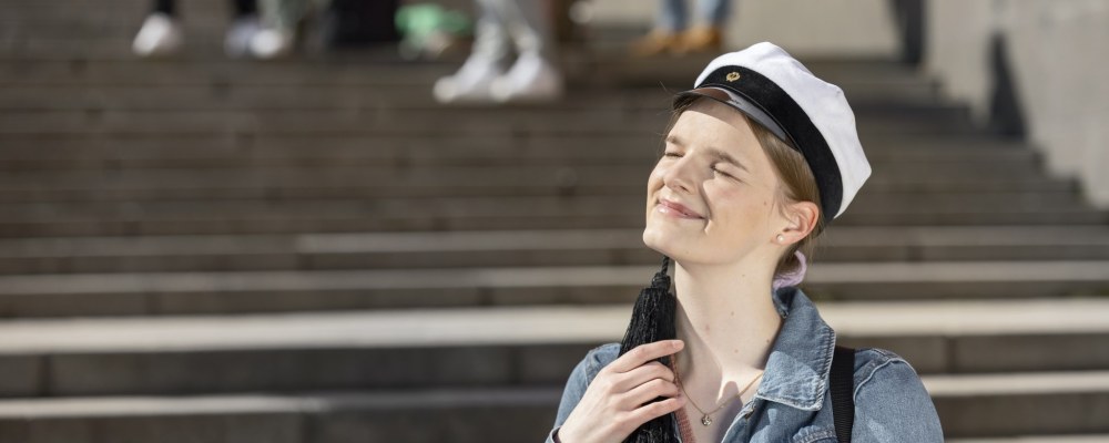 Henkilö teekkarilakki päässä.