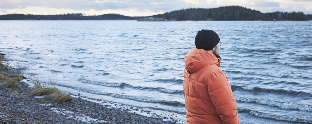 Henry Schwartz seisoo rannalla selin kameraan.