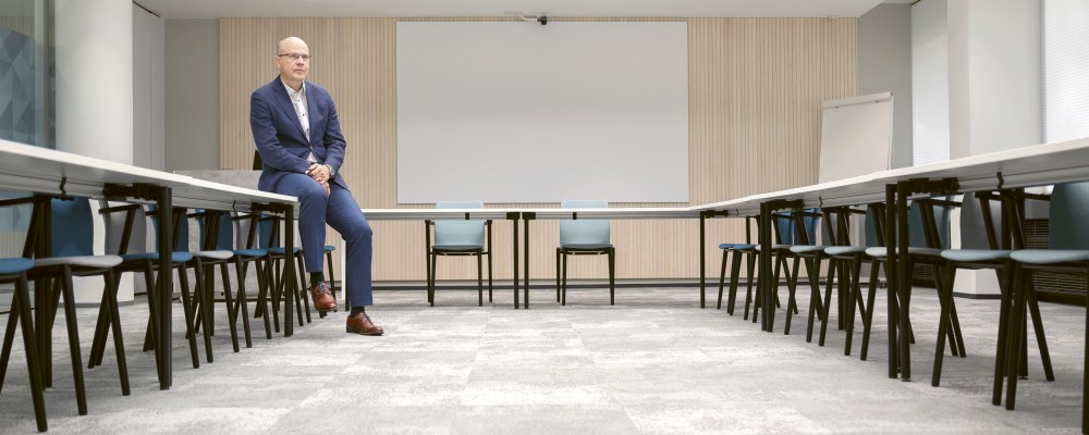 Teemu Hankamäki istuu tyhjässä neuvotteluhuoneessa.