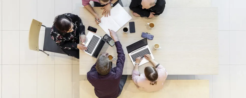 Ryhmä ihmisiä pöydän ääressä