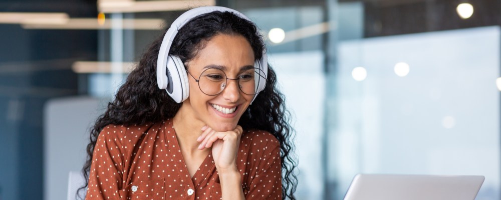 Nainen, kuulokkeet, tietokone