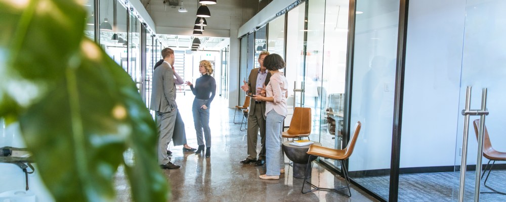 Henkilöitä keskustelemassa käytävällä.