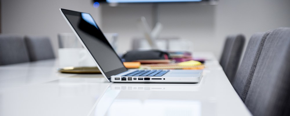 Läppäri neukkarin pöydällä.