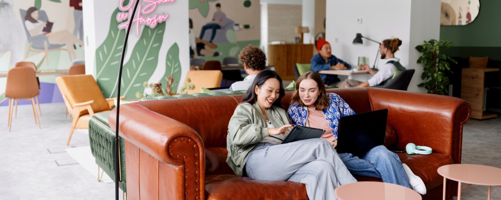 Nuoret henkilöt kahvilassa sohvalla.