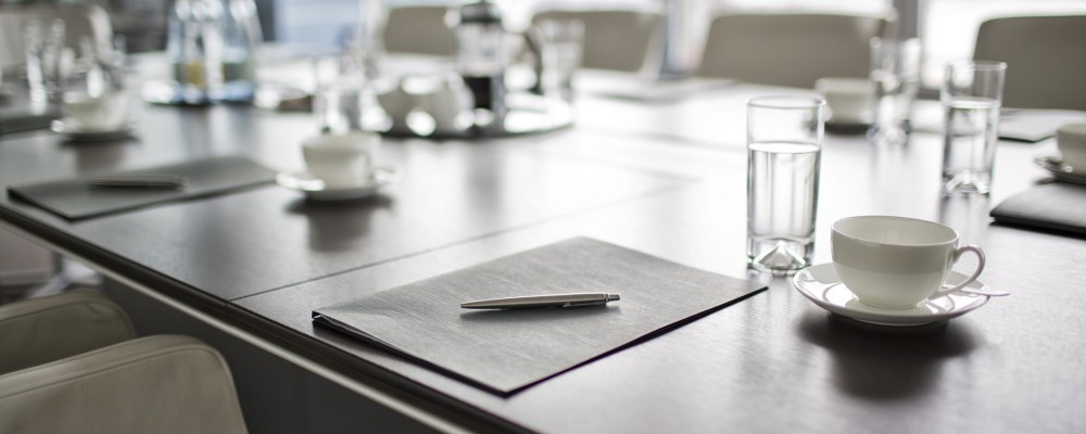 Kokouspöydällä papereita ja laseja.