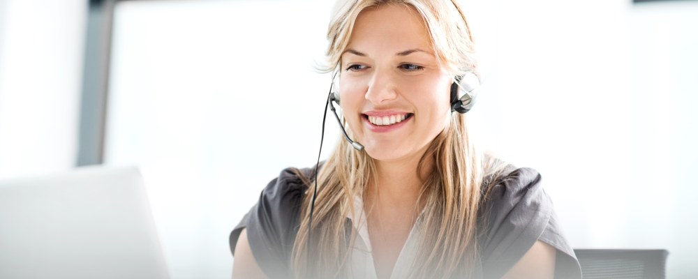 Henkilö kuulokkeet päässä läppärillä.