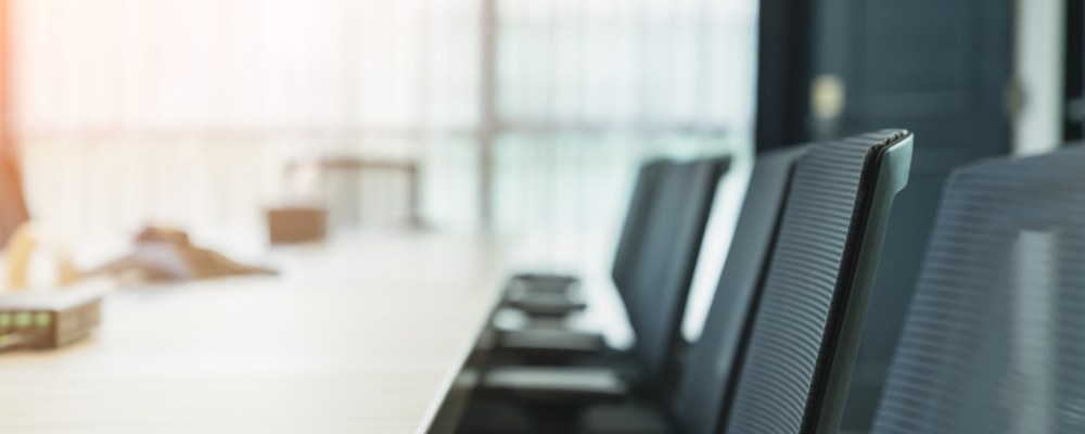 Tuoleja neuvottelupöydän äärellä.