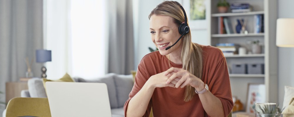 Henkilö istuu kotonaan tietokonee ääressä.