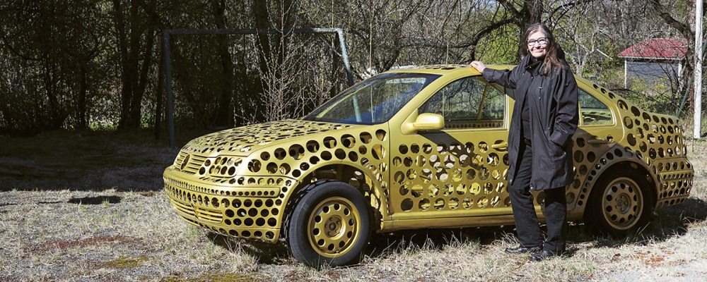 Anna-Kaisa Ant-Wuorinen kultaisen auton vieressä.