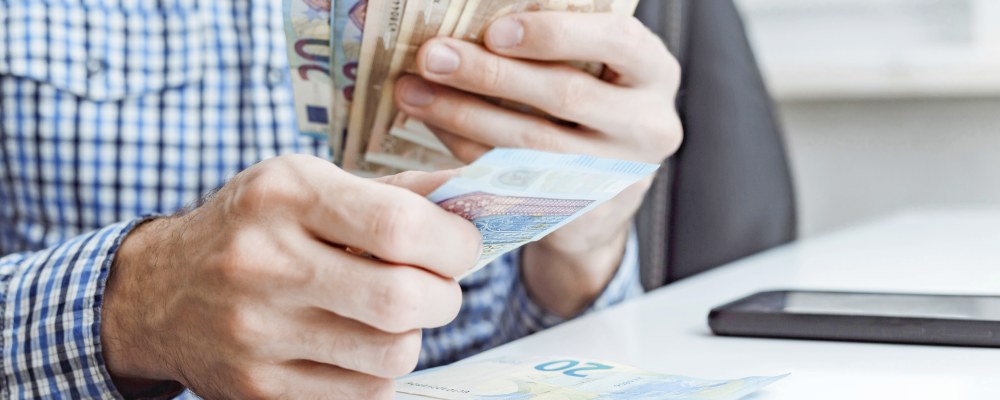 Mies laskee rahaa.