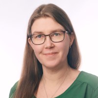 49-vuotias nainen, jolla on pitkät, ruskeat hiukset ja silmälasit.