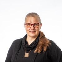 Pitkähiuksinen nainen mustassa puserossa