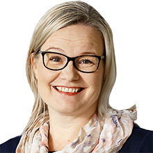 Outi Pekkarinen katsoo kameraan.