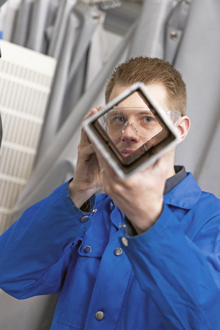 Lassi Keränen katsoo kameraan teräsputken läpi.