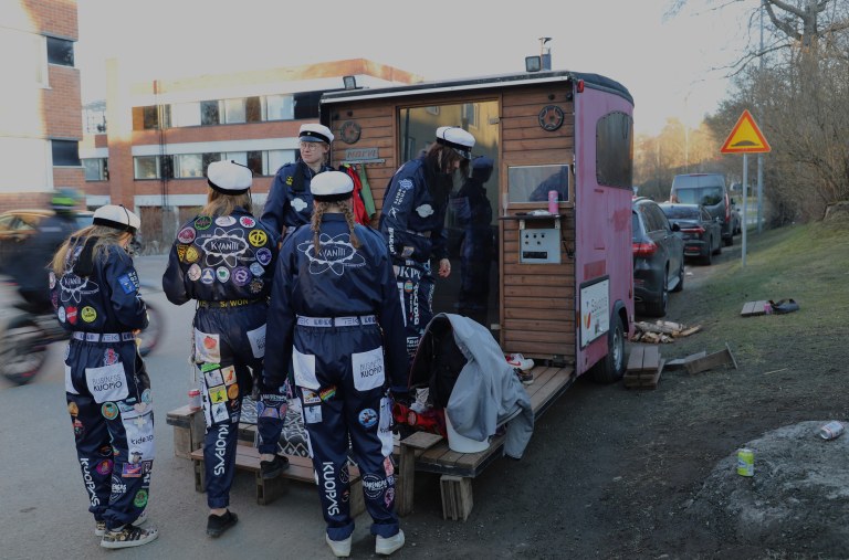 Sauna lähellä teekkarikastetta ja saunan edustalla saunomaan valmistautuvia opiskelijoita.