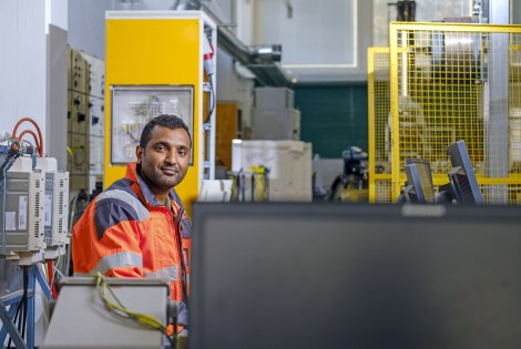 F. M. Mahafugur Rahman sähkötyötilassa päällään oranssi työtakki.