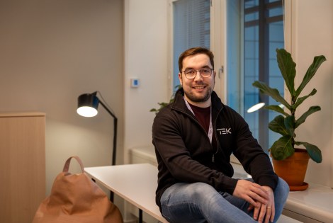 Owain Hopeaketo istuu toimiston pöydän kulmalla.