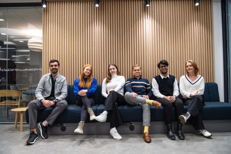 Teekkariporukka istuu sohvalla Kuopiossa.