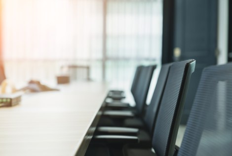 Tuoleja neuvottelupöydän äärellä.