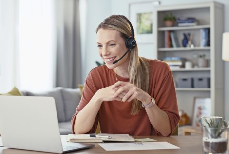 Henkilö istuu kotonaan tietokonee ääressä.