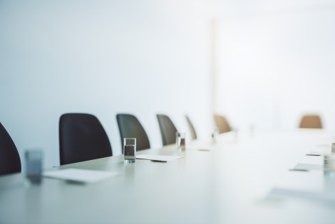 Tyhjiä tuoleja kokouspöydän ympärillä