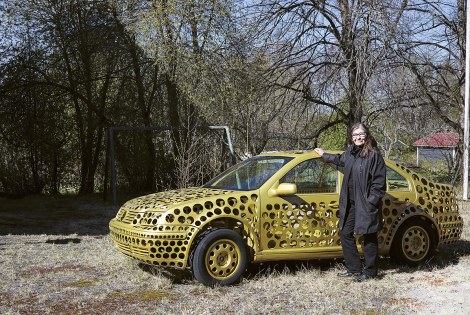 Anna-Kaisa Ant-Wuorinen kultaisen auton vieressä.