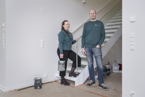 Katariina Laine ja Theo Ruokomaa katsovat kameraan työmaalla.