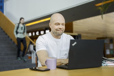 Henkilö läppärin kanssa.