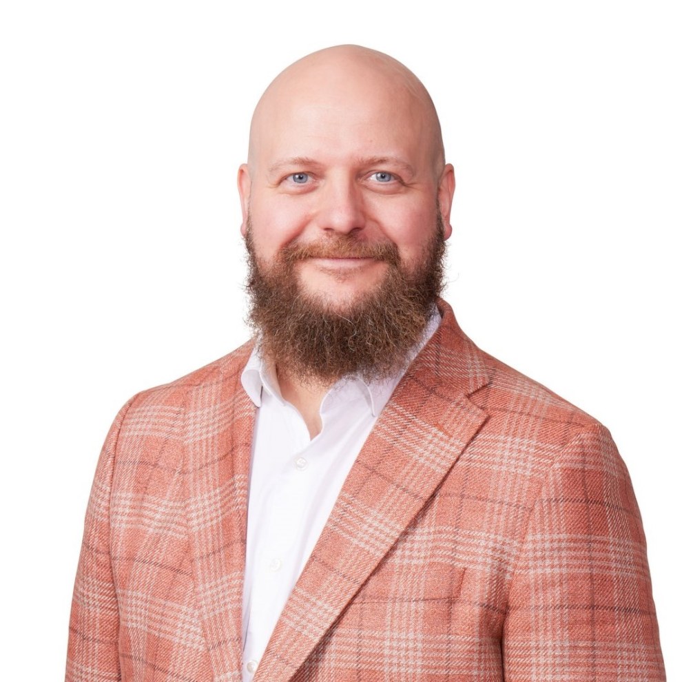 Kalle Airo, parrakas ja kalju mies punasävyisessä pikkutakissa